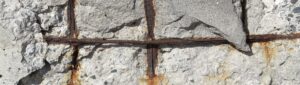 Concrete spalling may expose corroded reinforcing steel, but the visible damage does not necessarily reveal its full extent